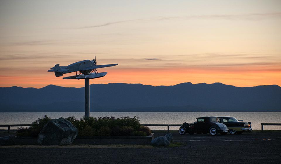 A road at dusk with cars and a small plane model