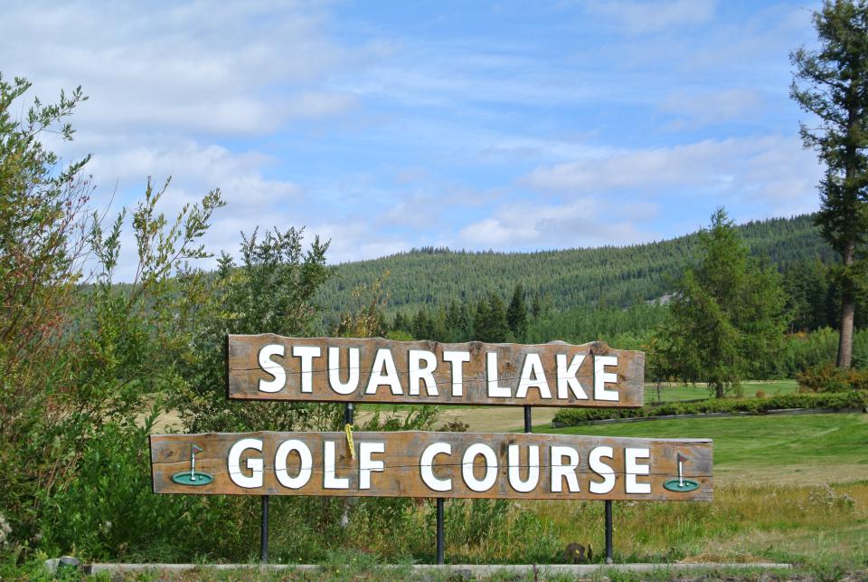 wooden sign for Stuart Lake Golf Course with trees in background
